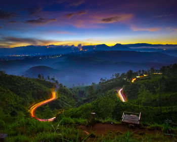 Scenic view of illuminated mountains against sky at sunset