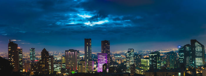 Illuminated cityscape against sky at night