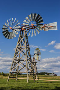 Low angle view of windmill on field against sky