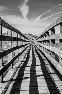 Shadow of footbridge against sky