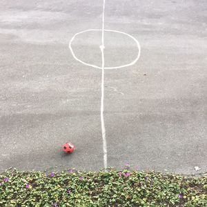 High angle view of soccer ball with chalk drawing on footpath