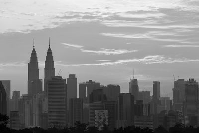 Buildings in city against cloudy sky