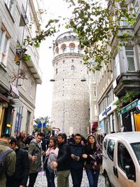 People on street amidst buildings in city