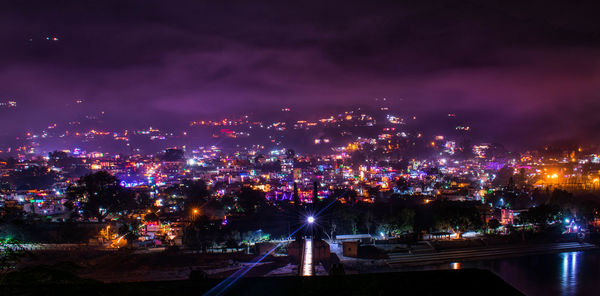 Illuminated cityscape against sky at night