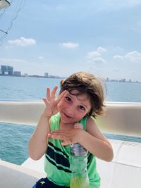 Portrait of cute girl in boat on sea against sky