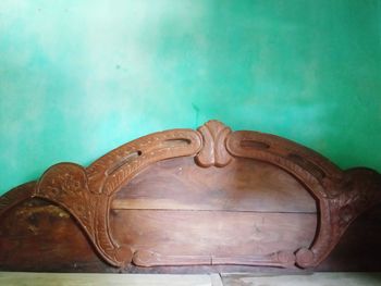 Close-up of old carving on table against wall