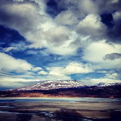 Scenic view of mountains against cloudy sky