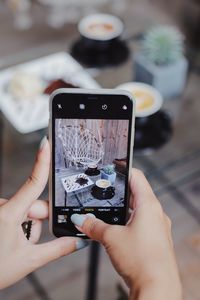 Midsection of man photographing with mobile phone