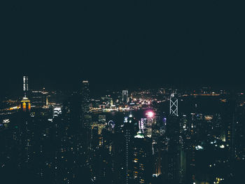 Illuminated cityscape against sky at night