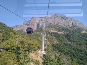 Overhead cable car against mountain