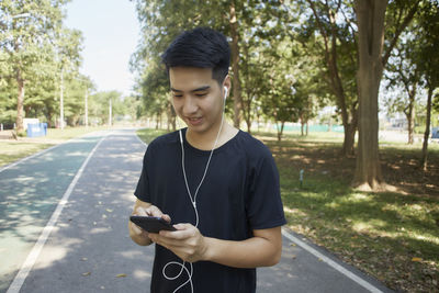 Young man using mobile phone in park