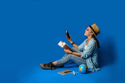 Low angle view of young woman using smart phone