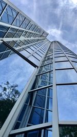 Low angle view of modern glass building against sky