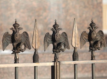 Close-up of metal railing against fence