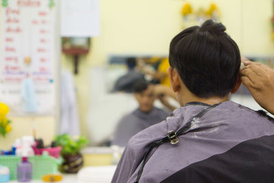 Rear view of two men at shop