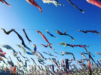 Low angle view of decoration hanging against clear blue sky