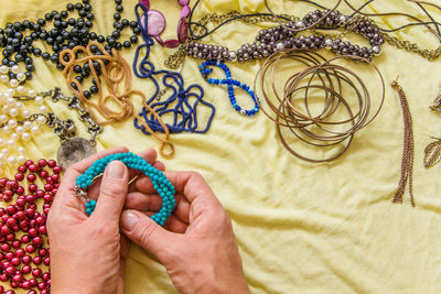 Cropped hands of woman holding bracelet indoors