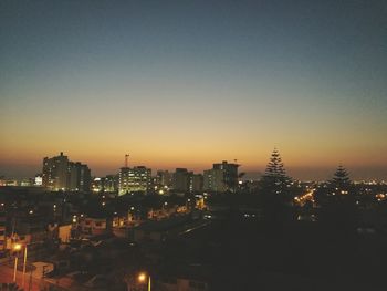 Illuminated cityscape against sky at night