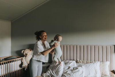 Happy mother playing with baby at home