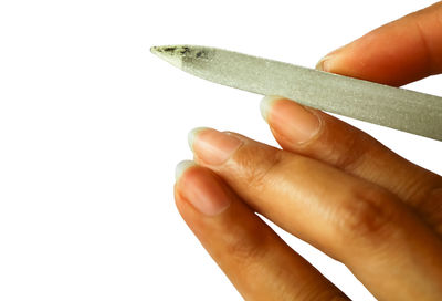 Close-up of woman filing nail over white background