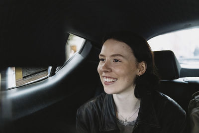 Smiling woman sitting in car on vacation