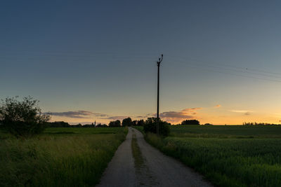 Scenic view of agricultural field against clear sky during sunset