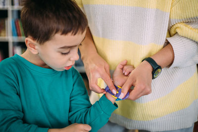Mom gives her son his first watch. learning to determine the time by the clock.
