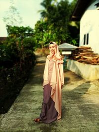 Full length portrait of woman standing outdoors