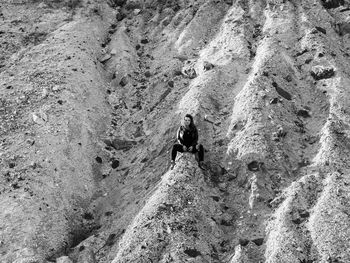 Full length of woman sitting on rock formation