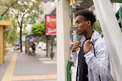 Young man looking away in city