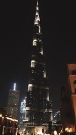 Low angle view of illuminated buildings against sky at night