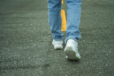 Low section of man standing on road
