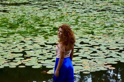 Young woman standing by lake