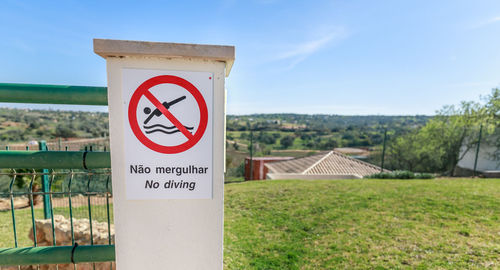 Information sign on field against sky