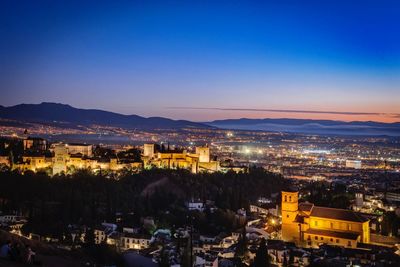 High angle view of illuminated city against sky at night