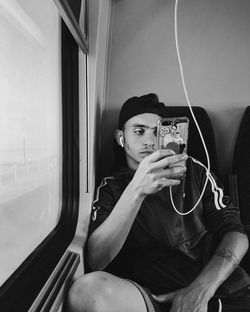 Full length of man sitting in train