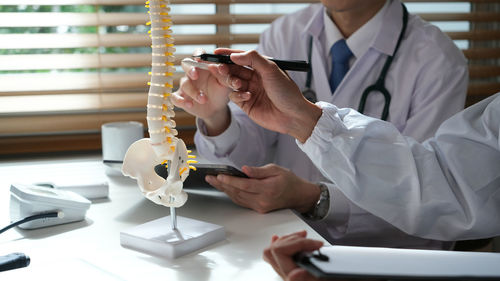 Midsection of businessman working on table