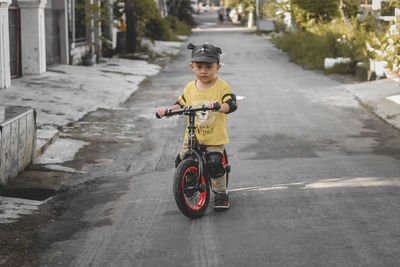 Portrait of cute 2 year old toddler riding a push bike