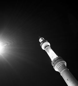 Low angle view of communications tower against sky at night