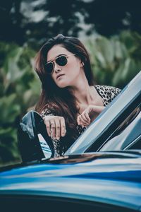 Woman wearing sunglasses by car