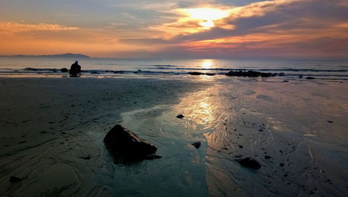 Scenic view of beach against sky during sunset