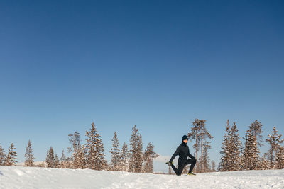 Winter outdoor activities. an athletic man does push-ups, warms up before jogging in a snow park