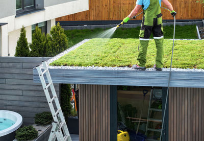 Low section of man standing in greenhouse