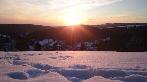 Scenic view of snowcapped mountains against sky during sunset