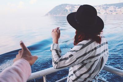 Rear view of woman at sea shore against sky