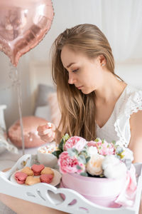 Portrait of smiling young woman holding food at home