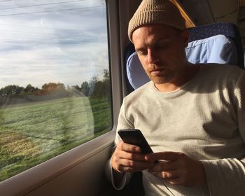 Man using mobile phone while traveling in train