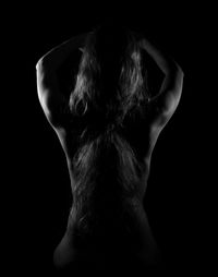 Rear view of woman against black background