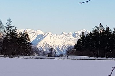 Snow covered land and mountains against sky