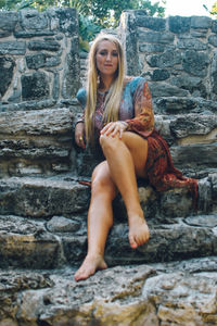 Portrait of young woman sitting on rock